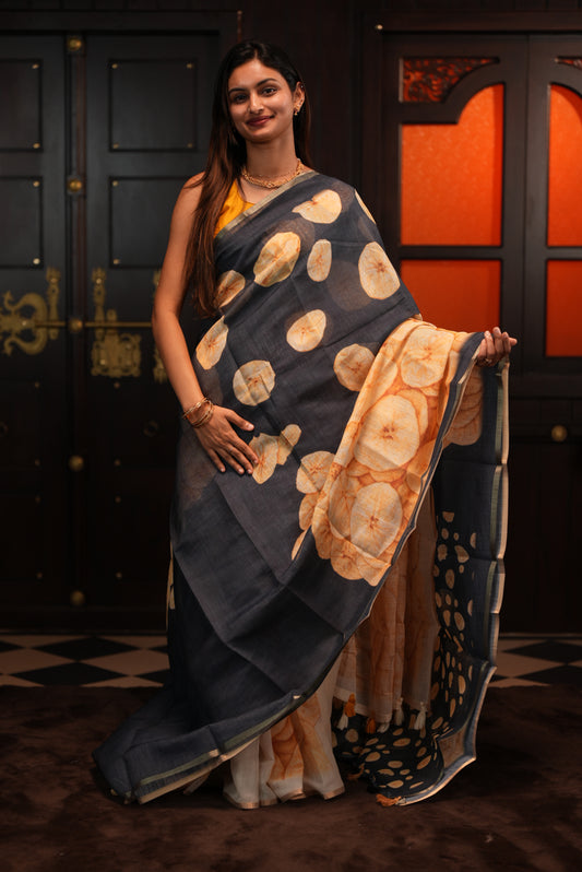 Black colour Semi Linen saree featuring Banana Chips Print with Gold Tissue Border, comes with tassels.