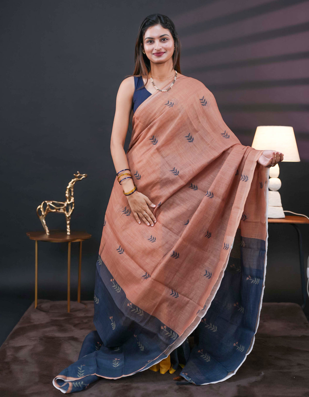 Chikku and black half and half semi linen saree having leaf and floral prints on body, contast colour printed pallu with tassels comes with matching Blouse Piece