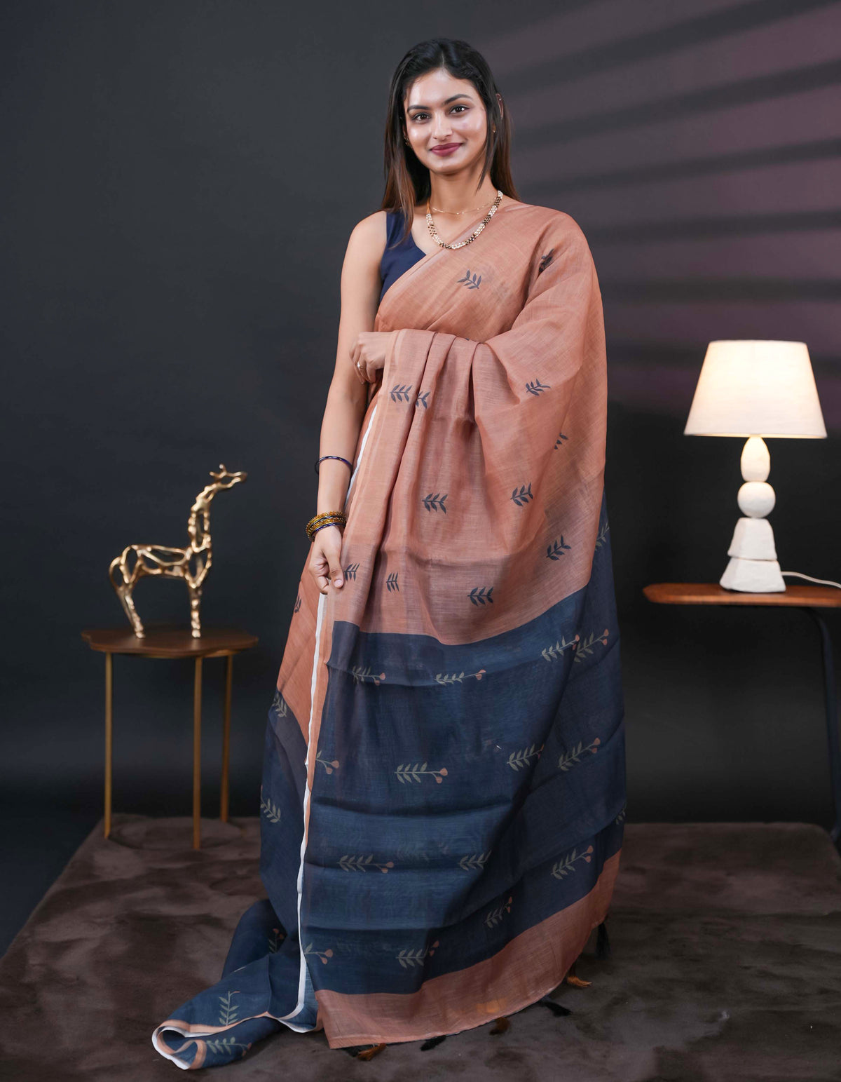 Chikku and black half and half semi linen saree having leaf and floral prints on body, contast colour printed pallu with tassels comes with matching Blouse Piece