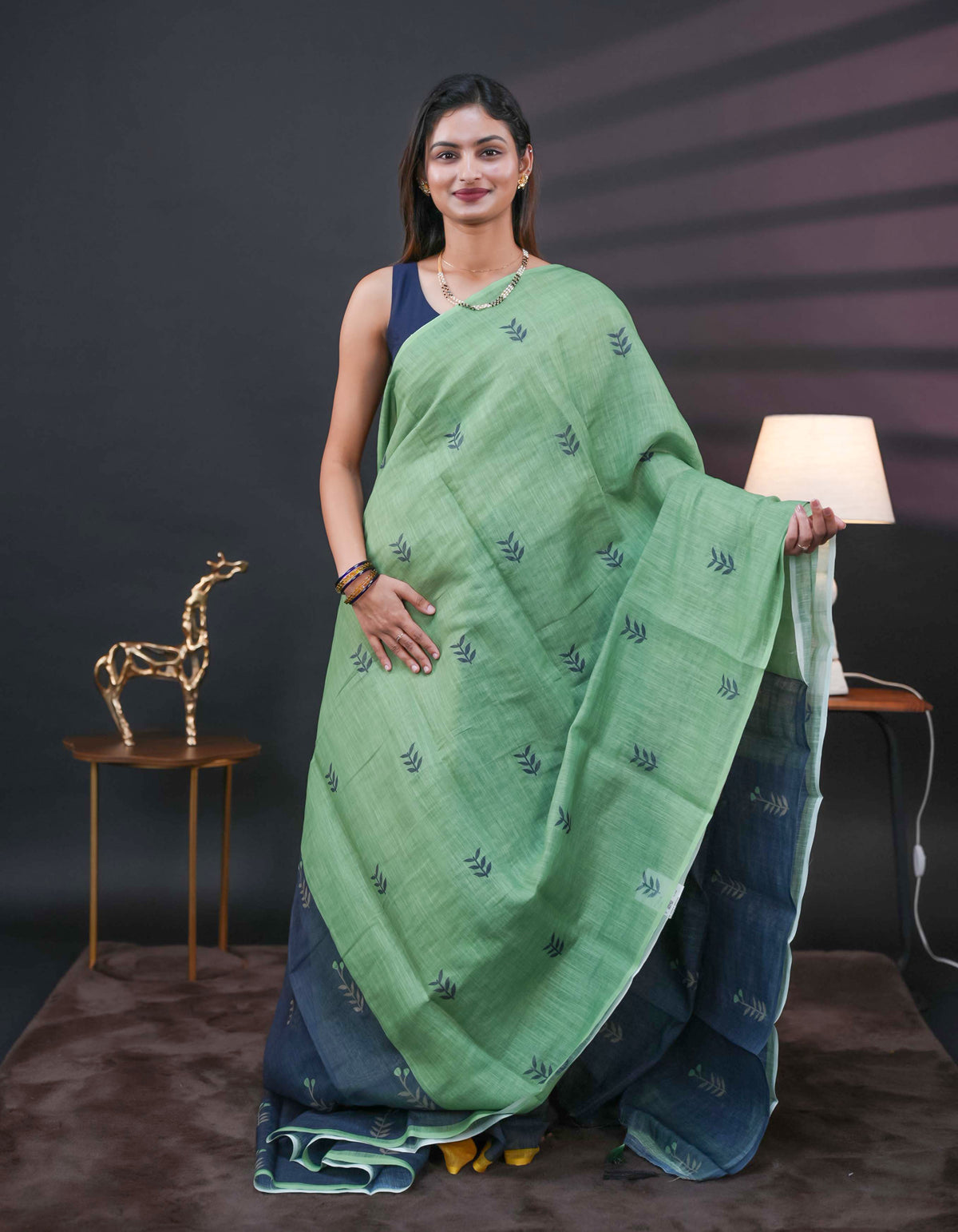 Pista Green and black half and half semi linen saree having leaf and floral prints on body, contast colour printed pallu with tassels comes with matching Blouse Piece