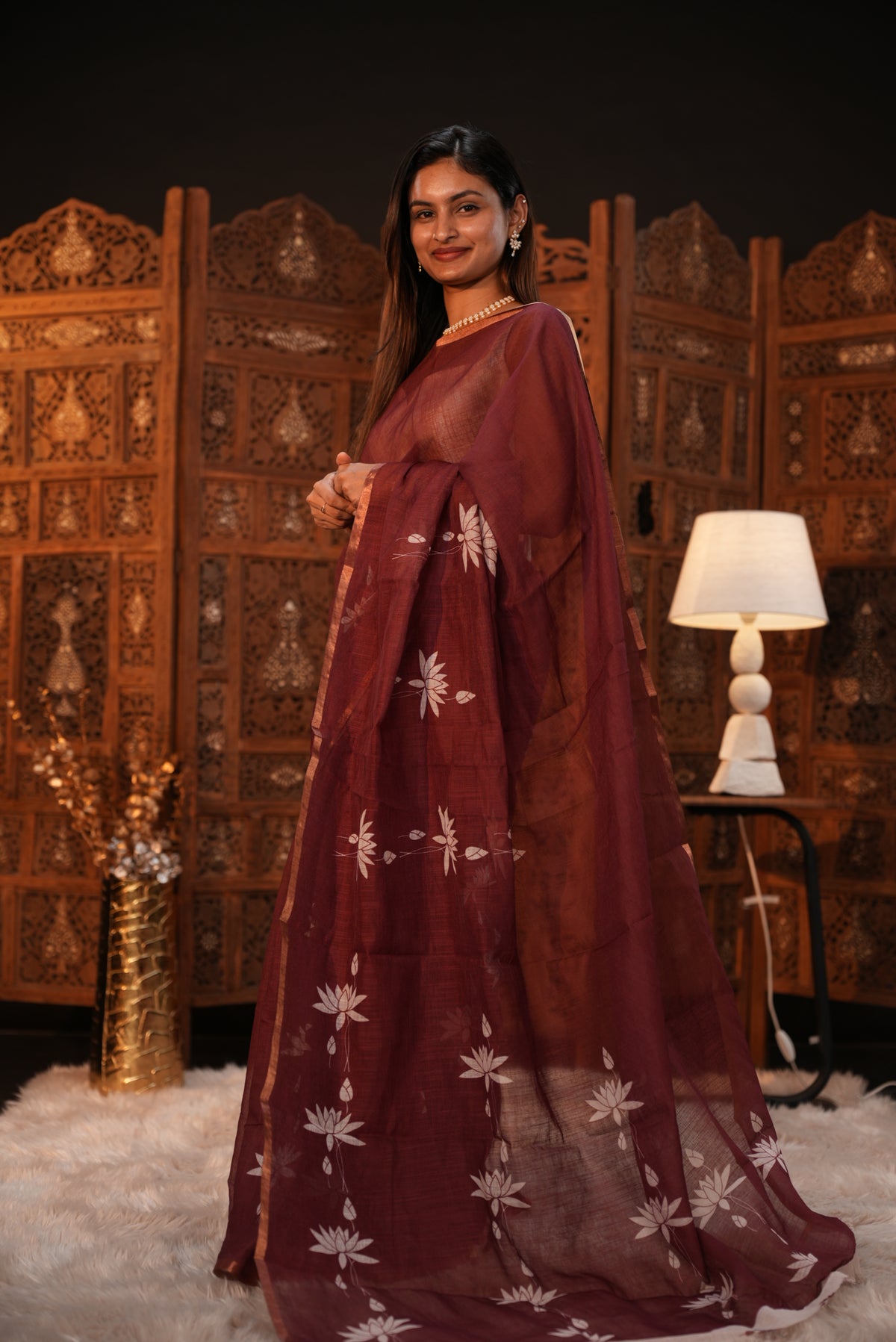 Maroon colour Semi Linen saree featuring plain & lotus print, Bavanchi border & same print on Pallu, comes with contrast colour blouse piece.