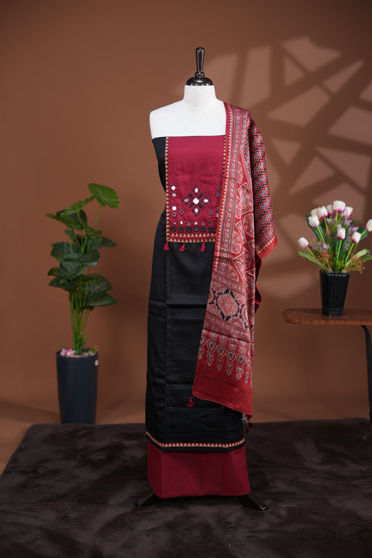 Black colour Jam Satin salwar material, Plain body with mirror & thread work on neck portion, matching bottom and Dupatta with ajrak print.
