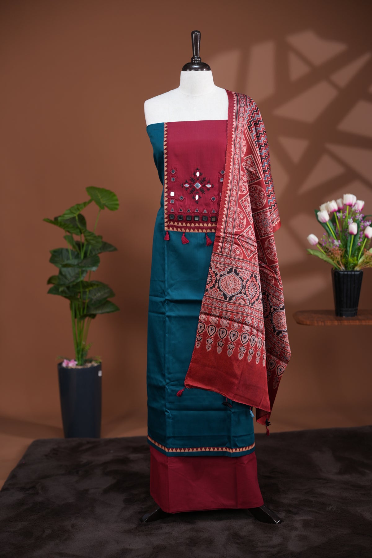 Peacock blue colour Jam Satin salwar material, Plain body with mirror & thread work on neck portion, matching bottom and Dupatta with ajrak print.