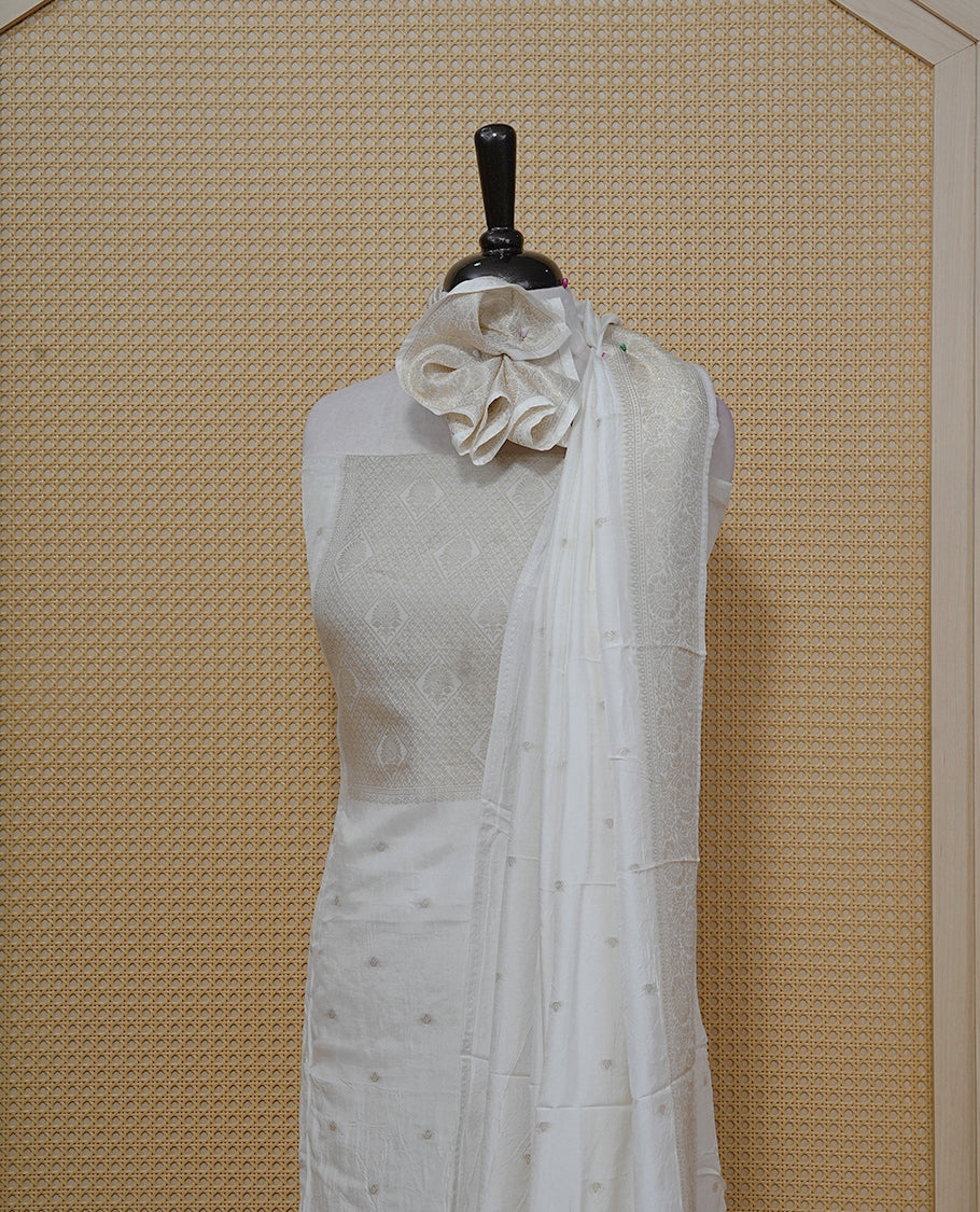 Cream colour Salwar material featuring gold zari Buttas on body & zari worked Neck Portion, paired with matching dupatta & Bottom.