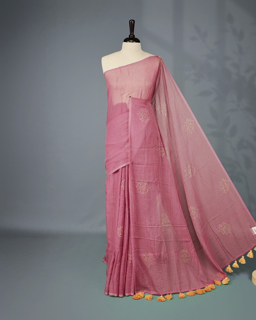 Onion colour pure mul cotton saree featuring Minimal Lotus Print on body, Clean Borderless design, elegant tassels.