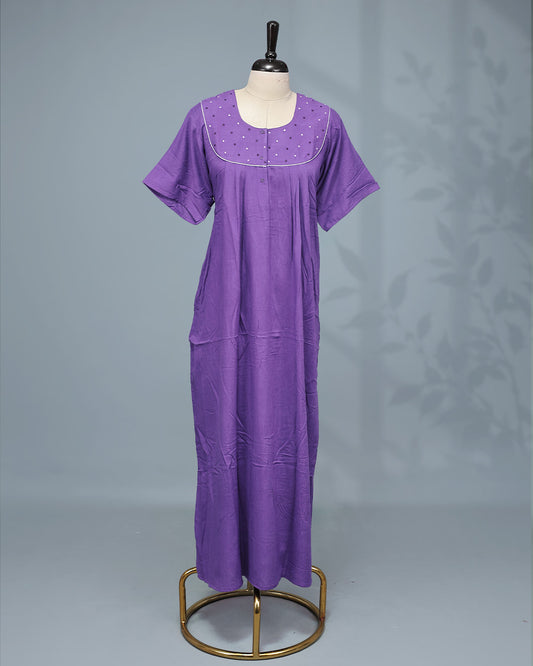 Elegant solid purple nighty featuring a round neckline with embellished yoke, delicate contrast piping, front button placket & half sleeve and a relaxed full-length fit for all-day comfort and graceful everyday wear.