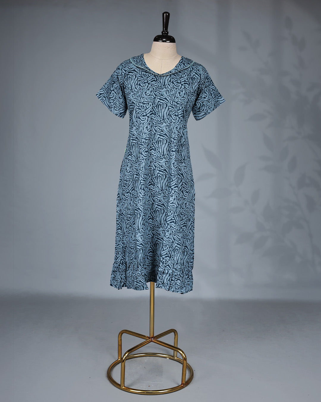 Greish Blue colour printed nighty featuring a graceful U-neckline with delicate lace trim, short sleeves and Mid-lenght fit.