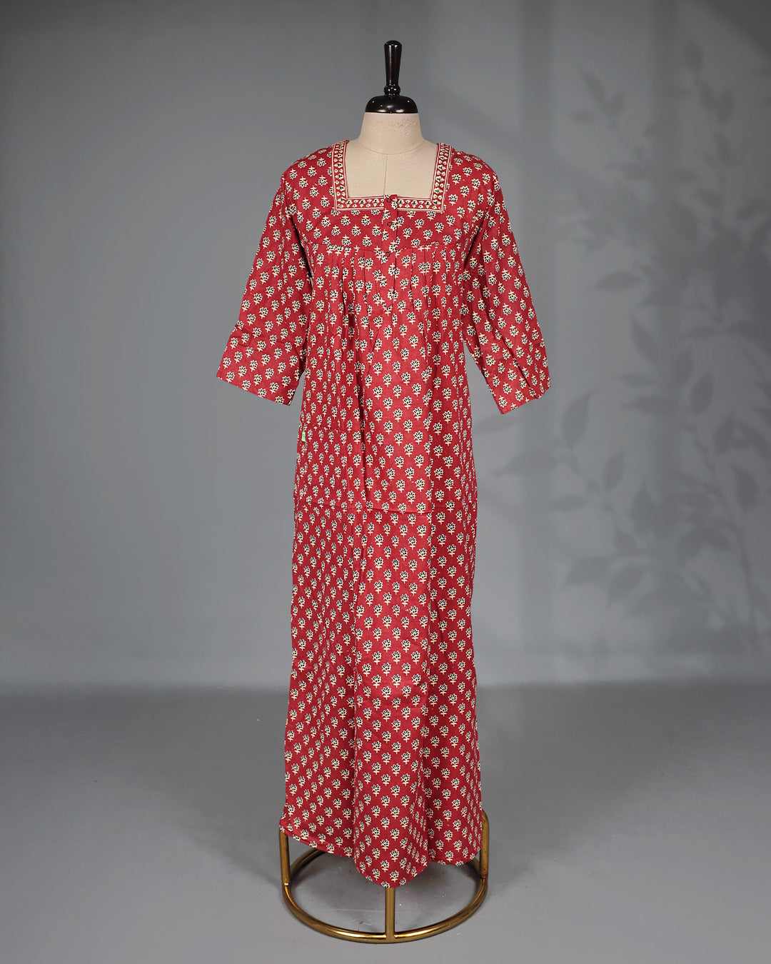Brick Red colour nighty adorned with cream floral prints, featuring an openable button-front square neckline, three-quarter sleeves, and an ankle-length fit