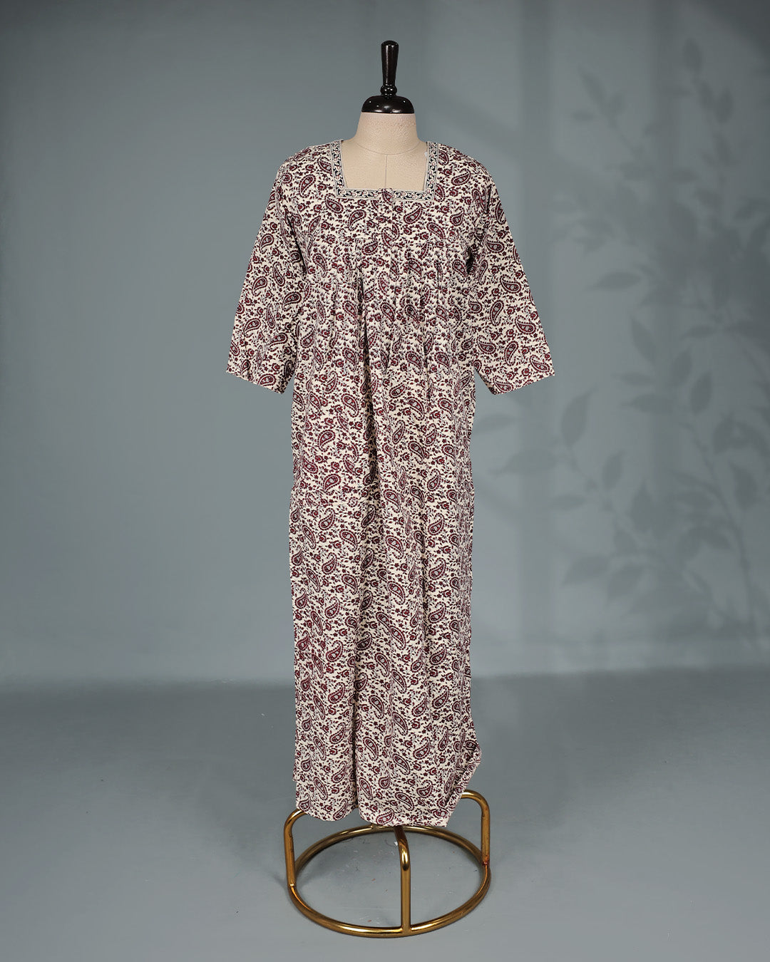 Cream and maroon paisley printed nighty with a classic square neckline, three-quarter sleeves, elegant border detailing and a relaxed full-length silhouette for everyday comfort and timeless style.