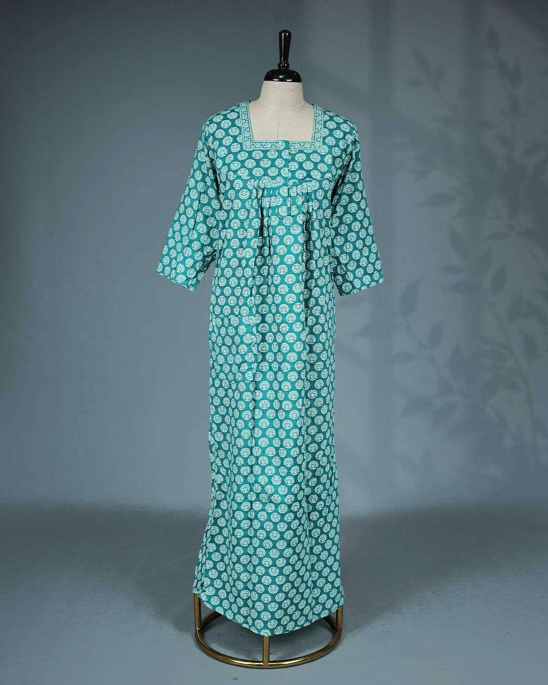 Teal colour printed nighty featuring a square neckline with contrast printed border & three-quarter and a comfortable full-length relaxed fit for everyday elegance and all-night comfort.