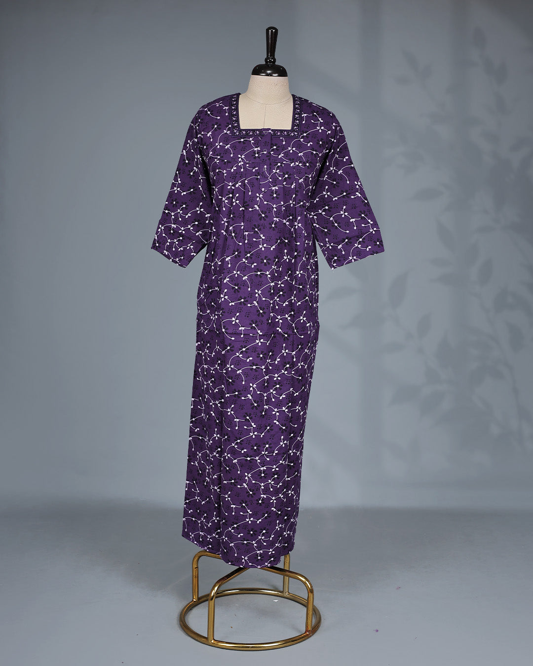 Purple colour printed nighty featuring a stylish square neckline with contrast border detailing, front button placket, soft pleated yoke, three-quarter sleeves and a relaxed full-length fit for everyday comfort and graceful style.