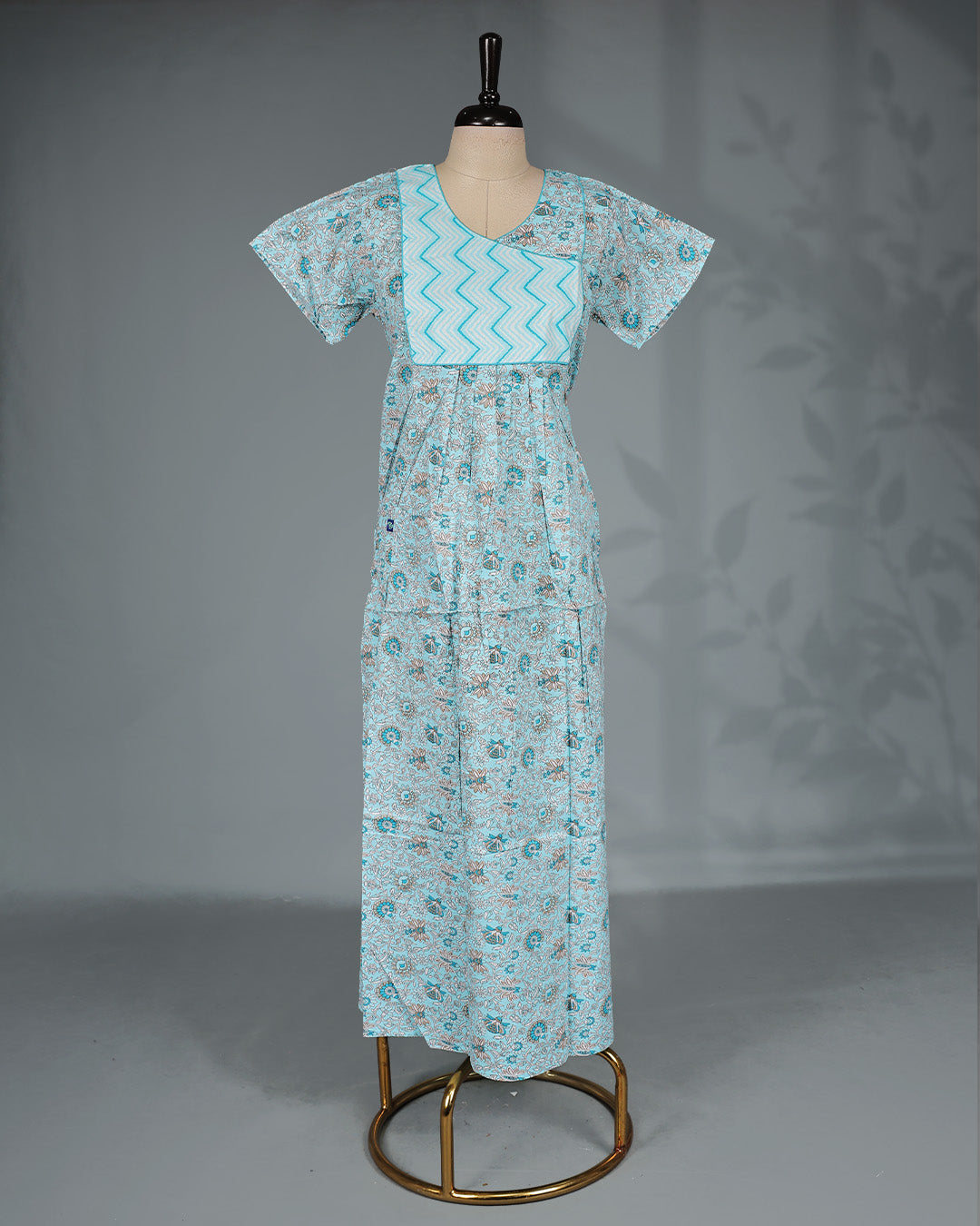 Sky blue floral kodi printed nighty with a stylish contrast asymmetrical yoke, V-neckline, short sleeves and ankle-length fit .