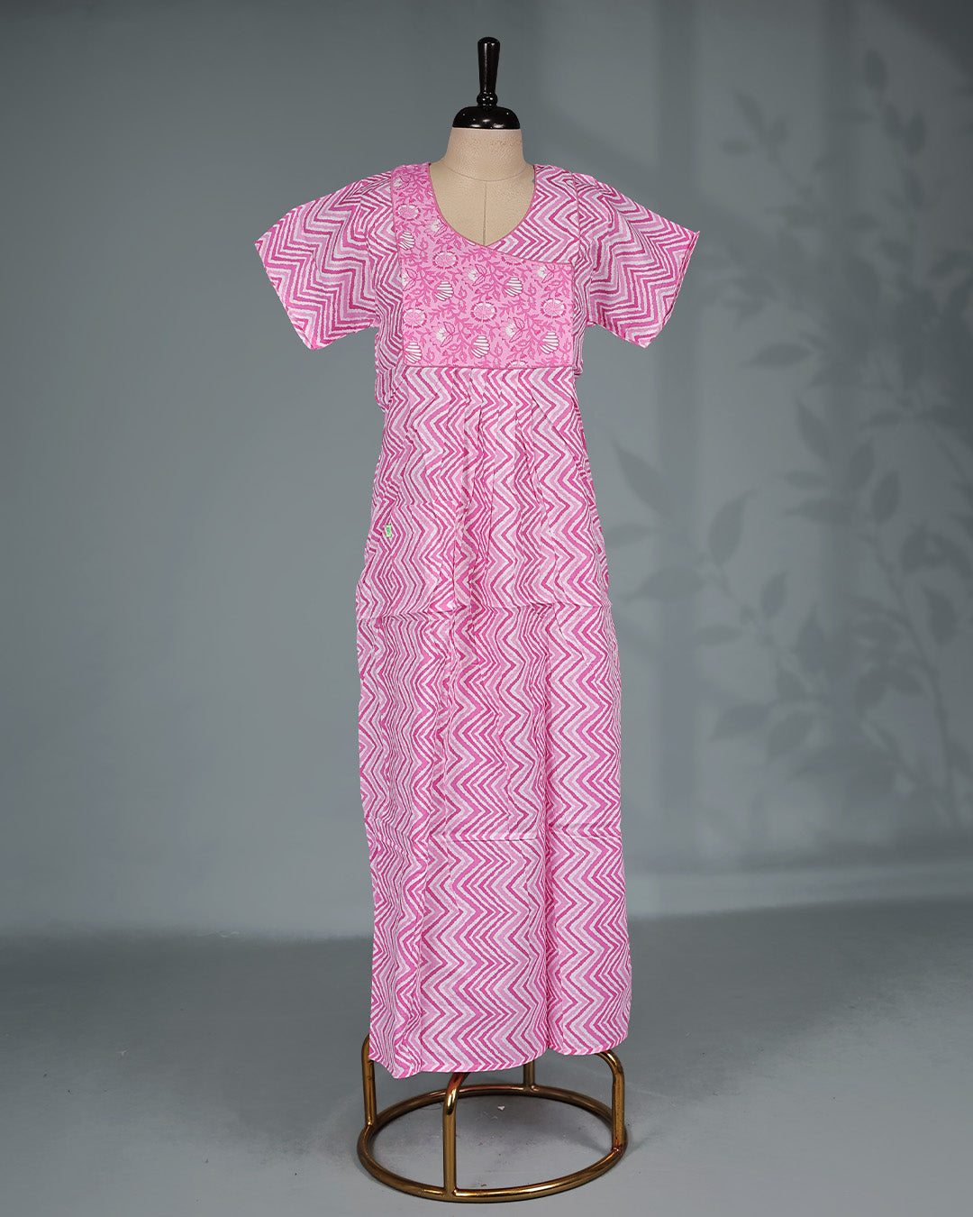 Pink colour nighty featuring a zigzag print with a floral yoke, a round neckline, short sleeves and an ankle-length fit.