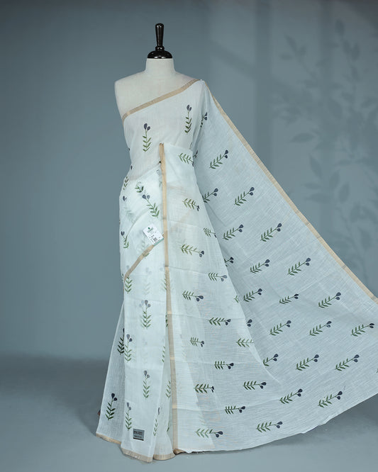 Off-white linen saree featuring beautiful Blue floral and leafy prints on the body, complemented by a tissue piping border and a contrasting pallu. Paired with a matching blouse piece.
