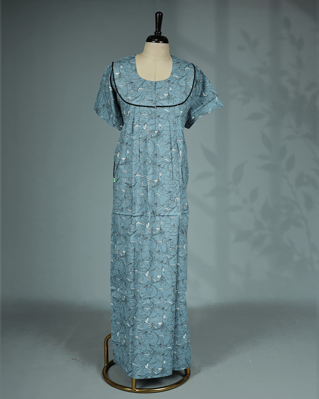 Dusty blue colour floral print nighty featuring an elegant U-shaped neckline with delicate black lace trim, soft pleated detailing, short sleeves and a relaxed full-length for all-day comfort and effortless style.