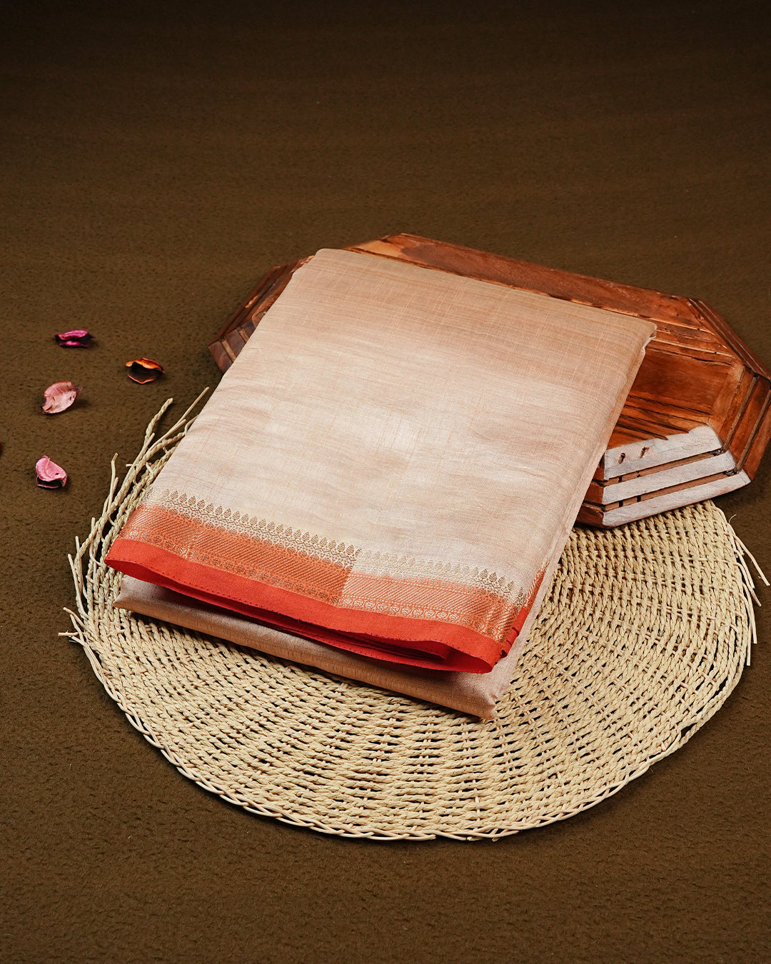 Cream colour Semi Tussar silk saree featuring an elegant plain body, accentuated by a contrast Orange border adorned with intricate gold zari work, paired with a matching blouse piece.
