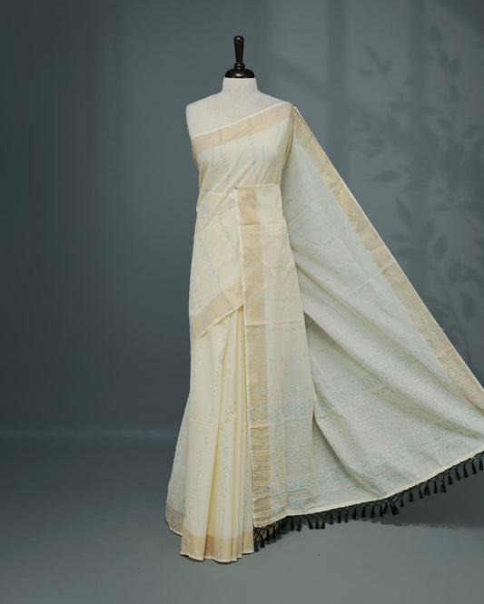 Cream colour Cotton kerala saree featuring Green & gold Strips on body, complemented by Gold zari Border, paired with matching blouse piece.