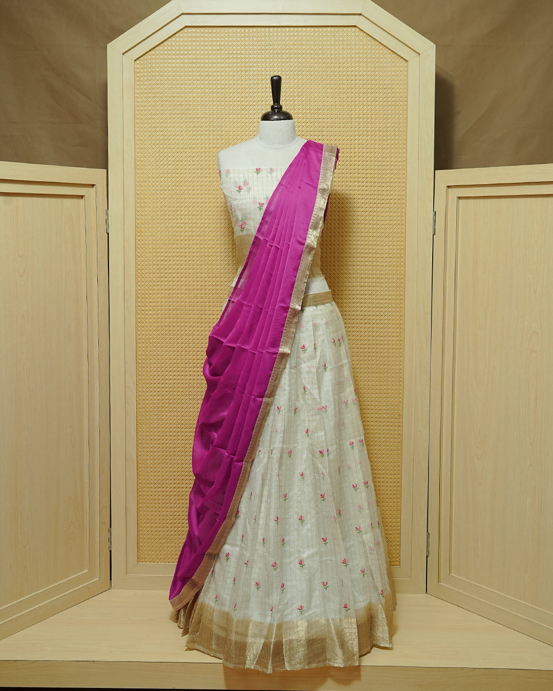 Cream colour Semi stitched Dhavani set featuring Gold zari checked pattern with floral motifs on skirt with traditional border, comes with contrast Colour Dupatta & matching blouse piece.