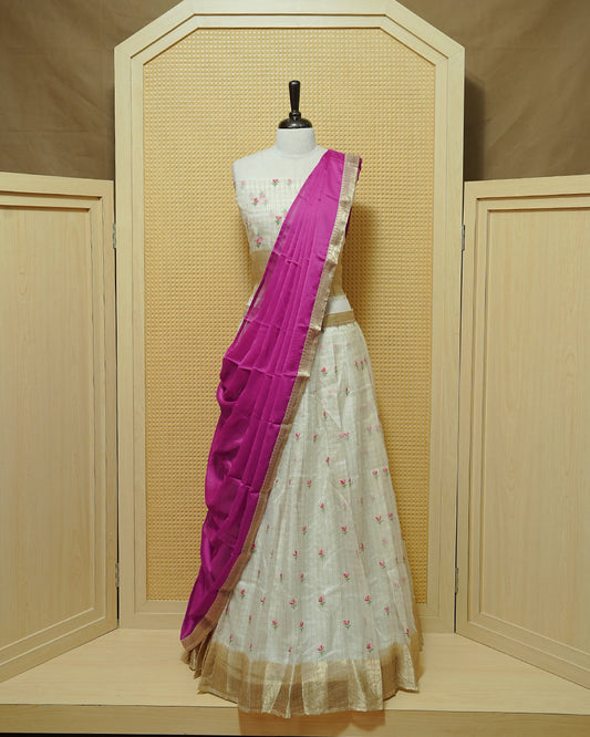 Cream colour Semi stitched Dhavani set featuring Gold zari checked pattern with floral motifs on skirt with traditional border, comes with contrast Colour Dupatta & matching blouse piece.
