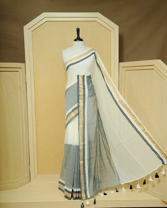 White  Colour Mul Cotton Saree featuring a grey and gold zari border with a matching grey pallu, finished with black and white tassels.