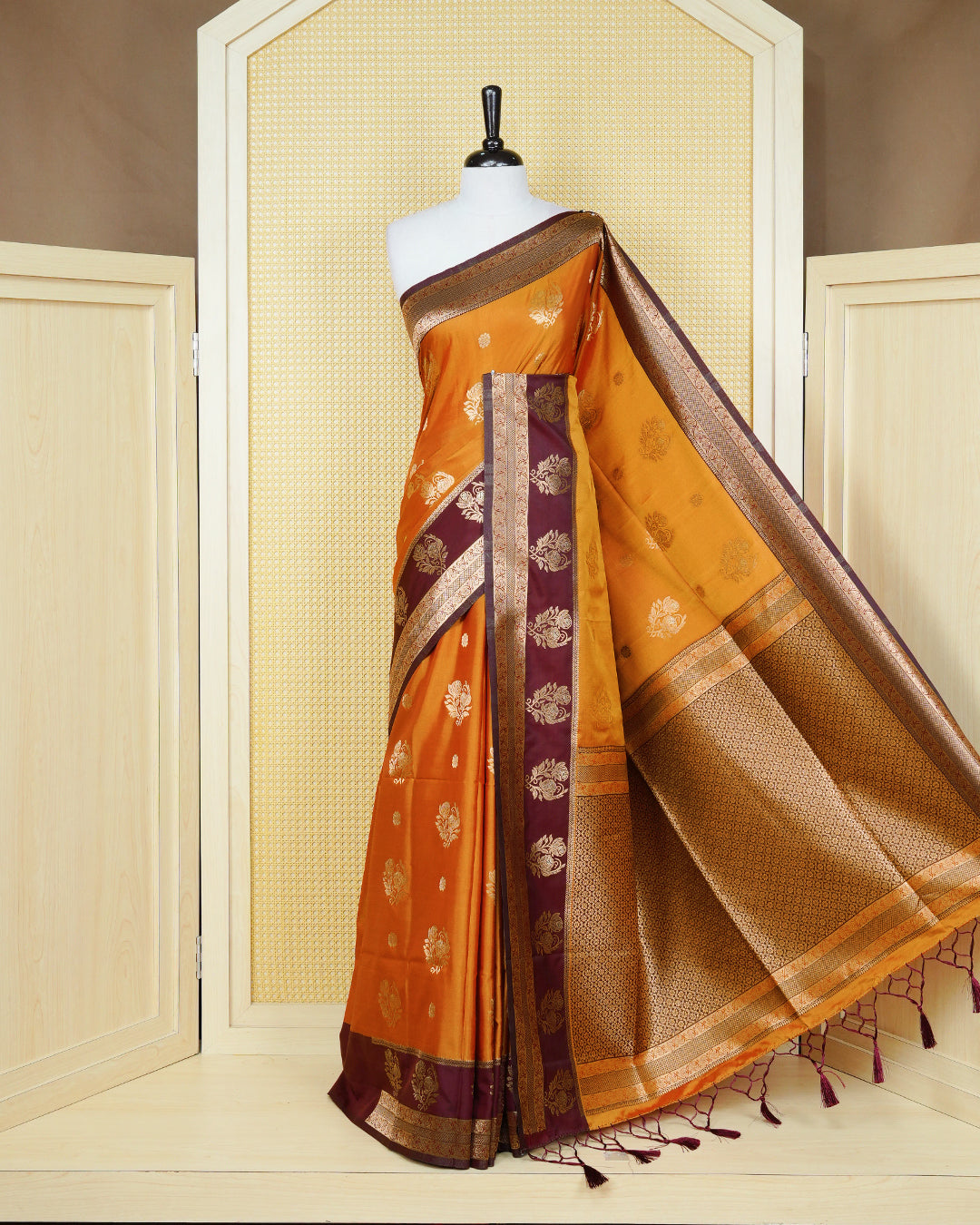 Rust orange colour Mulberry silk saree featuring gold floral zari patterns on body, paired with contrast maroon colour with traditional border, comes with matching blouse piece.
