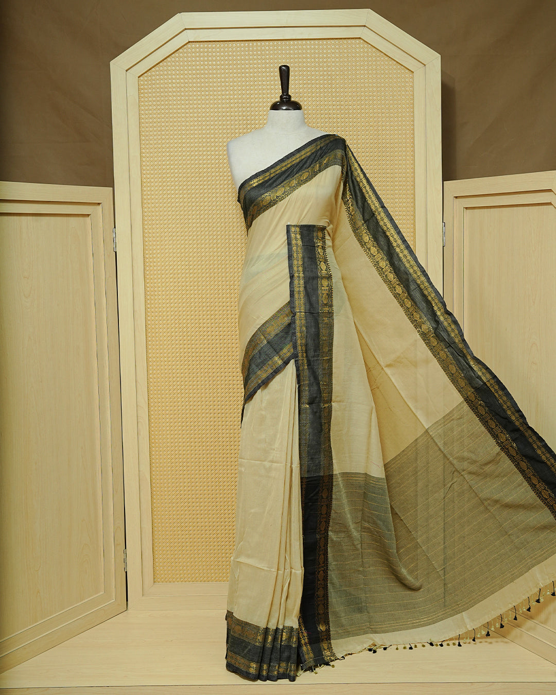 Beige Colour  Mul Cotton Saree featuring an elegant plain body, complemented by a black contrast zari border and matching black tassels