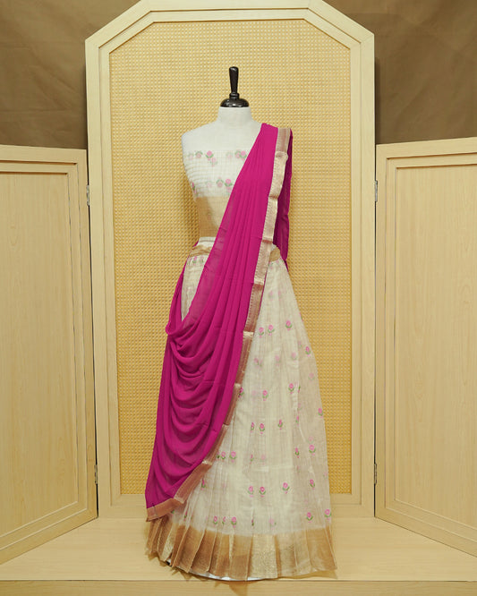 Cream colour Semi stitched Dhavani set featuring Gold zari checked pattern with floral motifs on skirt with traditional border, comes with contrast Colour Dupatta & matching blouse piece.