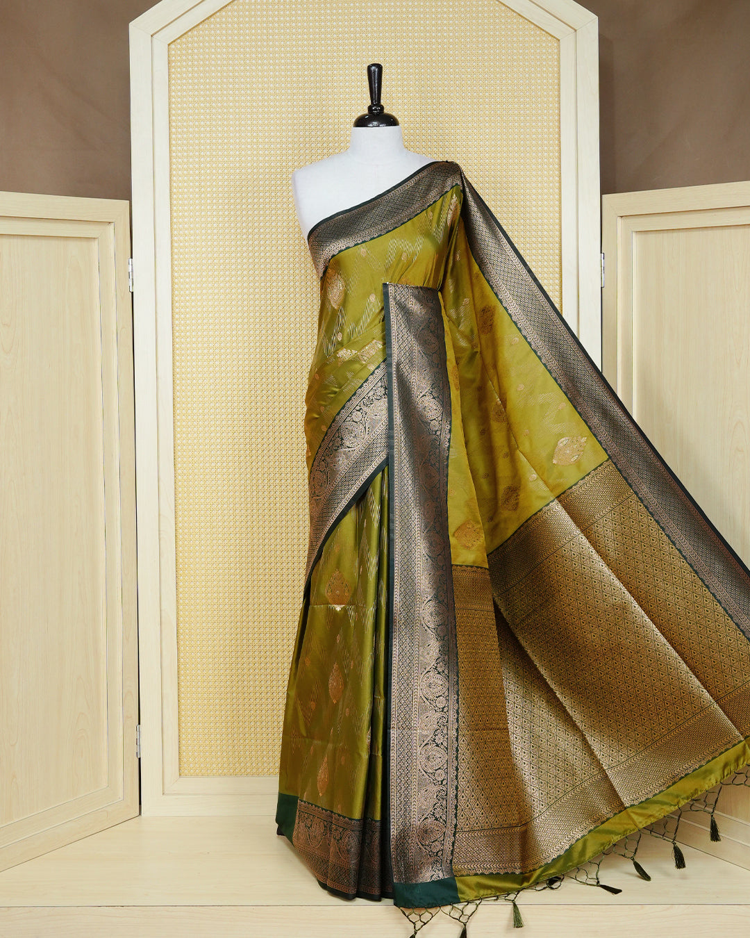 Olive colour Mulberry silk saree featuring floral gold zari patterns on body, paired with contrast bottle green colour with traditional border, comes with matching blouse piece.