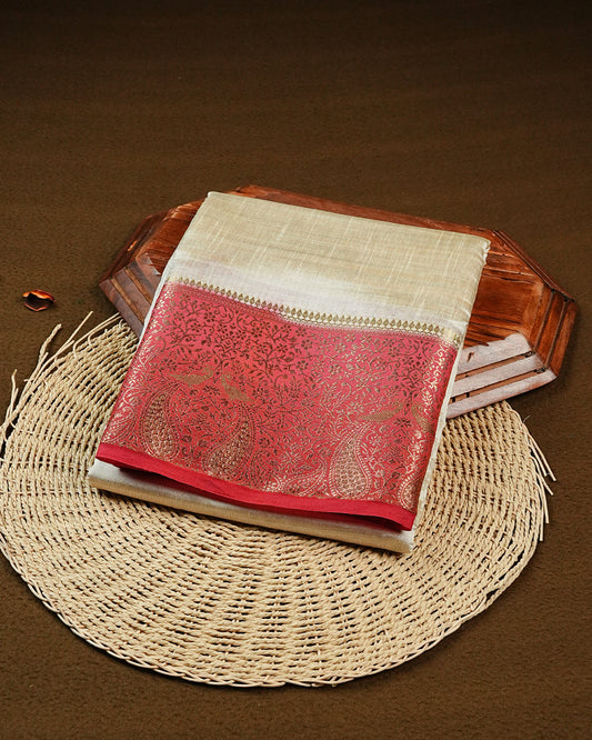 Light gold tussar saree featuring Elegant plain body, complemented by contrast Red colour with Gold zari Floral kodi with Peacock Pattern border, comes with matching blouse piece.