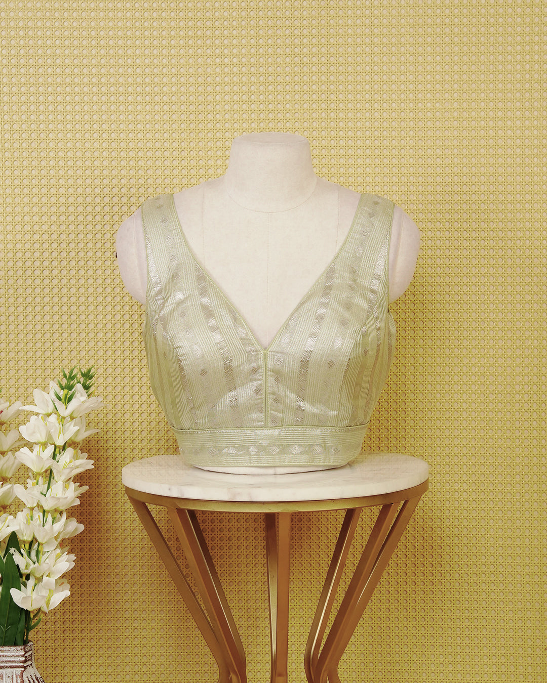 Light Sage green colour Sleeveless Blouse Featuring A Stylish V-Neck, Elegant Woven Zari Stripes With Butta Motifs, And A Comfortable Tailored Fit.
