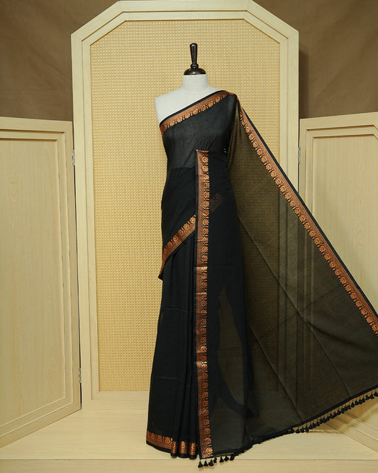 Black Colour Mul Cotton Saree featuring a plain body, complemented by a copper zari border and black tassels.