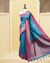 Teal colour Mulberry silk saree featuring floral gold zari patterns on body, paired with contrast Purple colour with traditional border, comes with matching blouse piece.