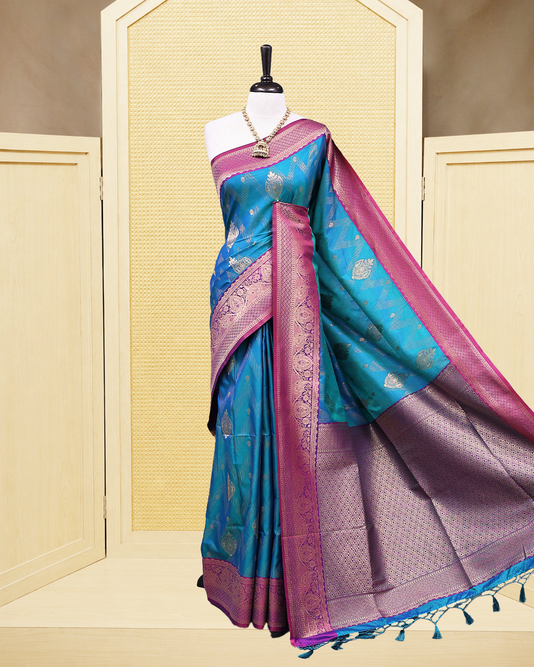 Teal colour Mulberry silk saree featuring floral gold zari patterns on body, paired with contrast Purple colour with traditional border, comes with matching blouse piece.