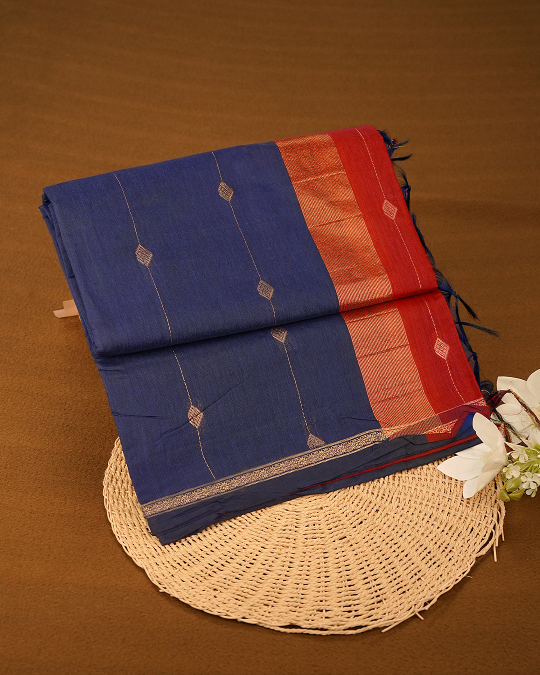 Navy Blue  colour Kalyani cotton saree featuring a gold zari floral pattern on the body, complemented by a Maroon pallu with gold zari stripes and a floral zari border, paired with a matching blouse piece