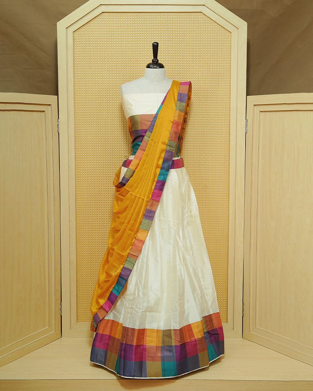 Cream colour Semi stitched Dhavani set Featuring Cream elegant plain with Mutlicolour bos patterned border skirt, comes with matching blouse piece & dupatta.
