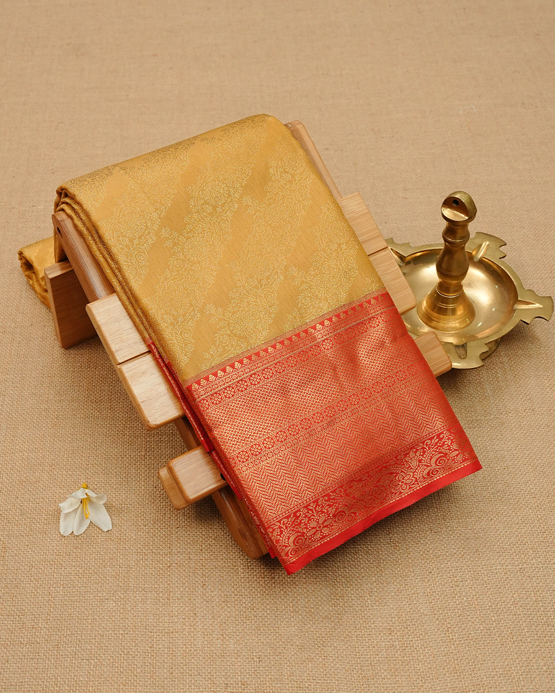 Mustard gold colour semi wedding saree featuring elegant self gold zari motifs on the body, complemented by a contrast red traditional zari border and a rich zari pallu. Paired with a matching blouse piece,