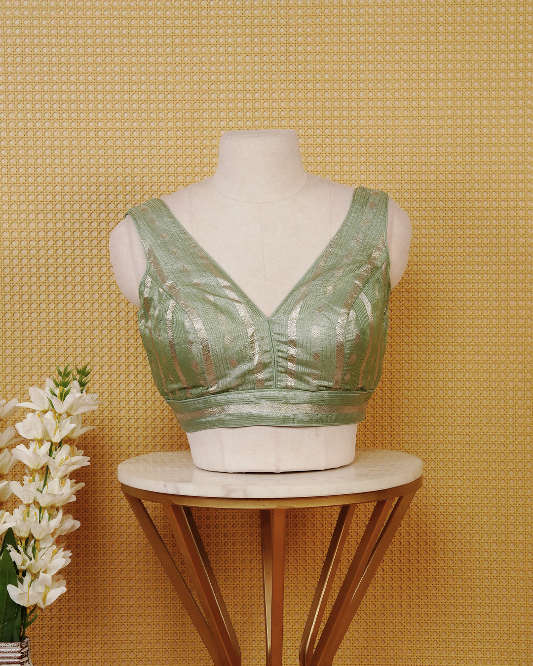 Sage Green colour Sleeveless Blouse Featuring A Stylish V-Neck, Elegant Woven Zari Stripes With Butta Motifs, And A Comfortable Tailored Fit.