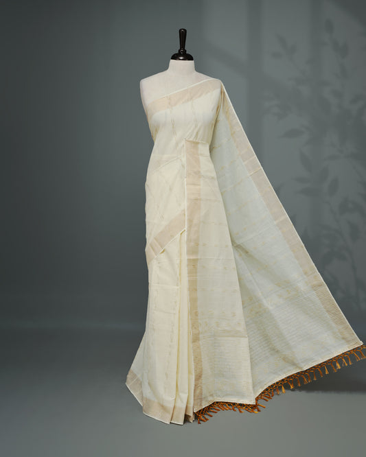 Cream colour Cotton kerala saree featuring Gold Embroidery strips on the body, complemented by a gold zari Border, Yellow elegant tassels, paired with a matching blouse piece.
