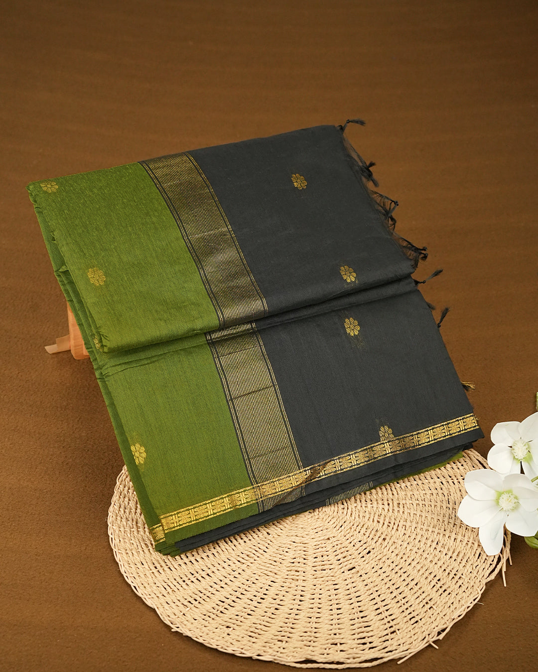 Light Green colour kalyani cotton saree featuring gold zari Floral pattern on body, complemented by Black colour with Stripes & Floral Gold zari border, paired with matching blouse piece