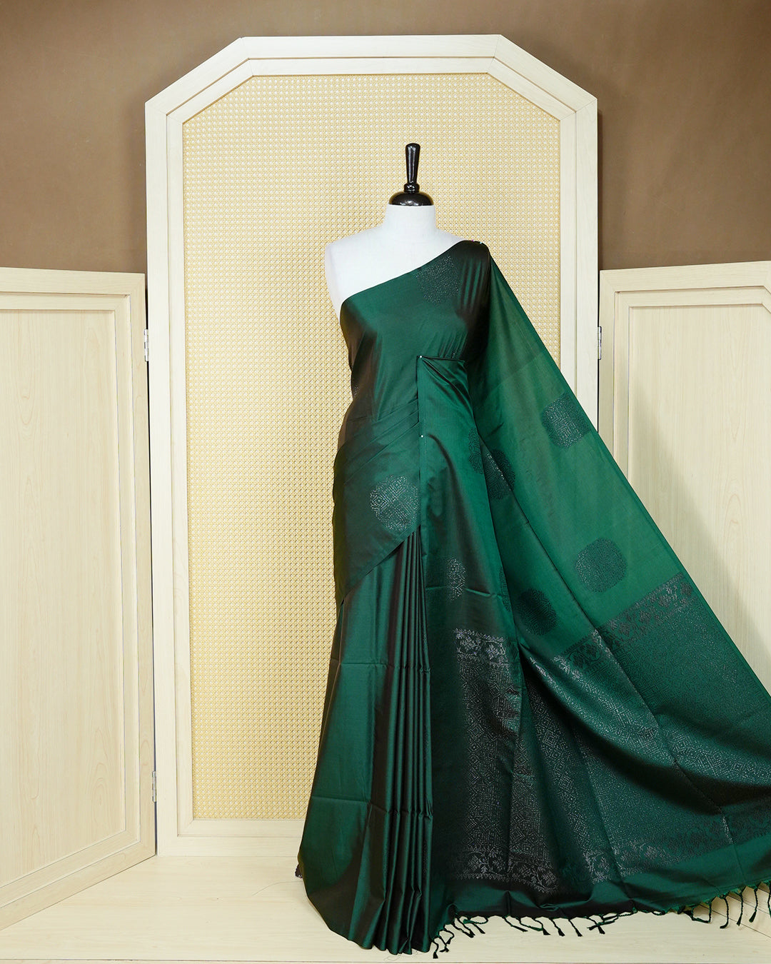 Dark forest green colour soft silk saree featuring antique zari motifs on body with contrast self colour pallu & paired with matching blouse piece.