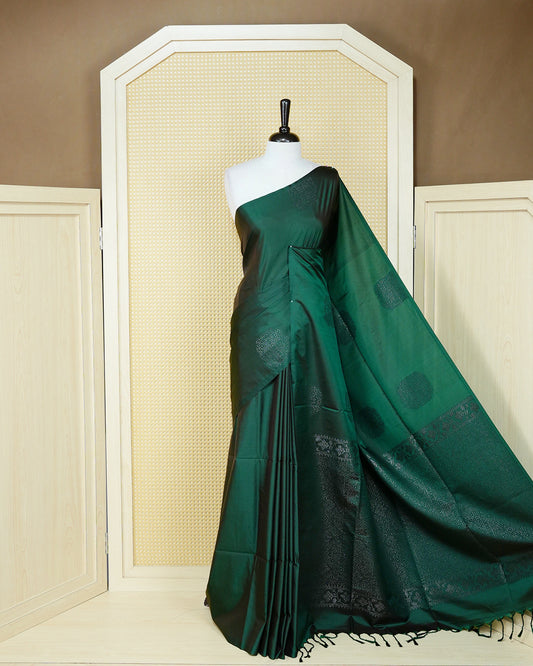 Dark forest green colour soft silk saree featuring antique zari motifs on body with contrast self colour pallu & paired with matching blouse piece.