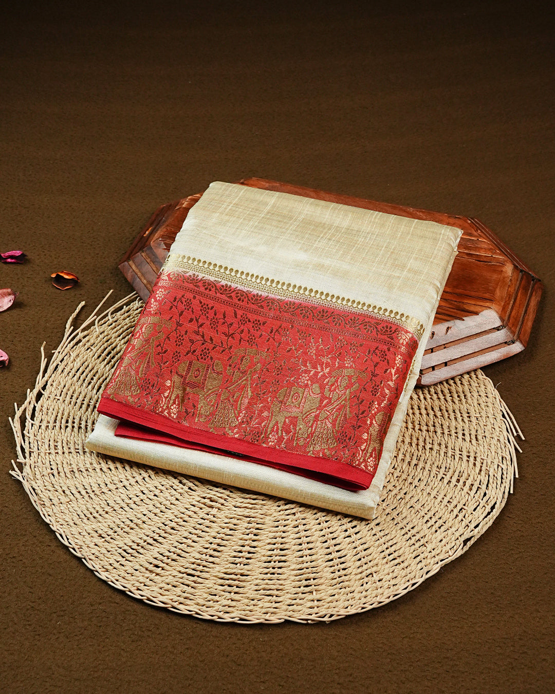 Light gold tussar saree featuring Elegant plain body, complemented by contrast Red colour with Gold zari Floral kodi with Elephant Pattern border, comes with matching blouse piece.