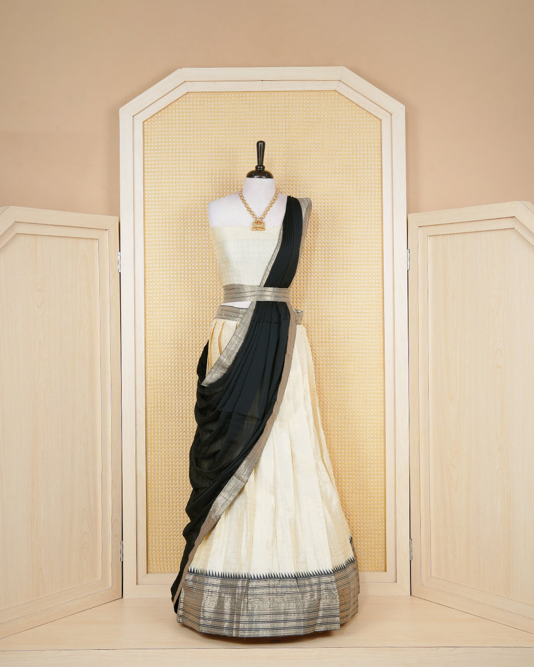 Cream colour  tissue Semi stitched dhavani set featuring Gold zari check pattern with motifs on body ,contrast Black colour with gold zari bordered skirt, paired with matching blouse piece & dupatta.