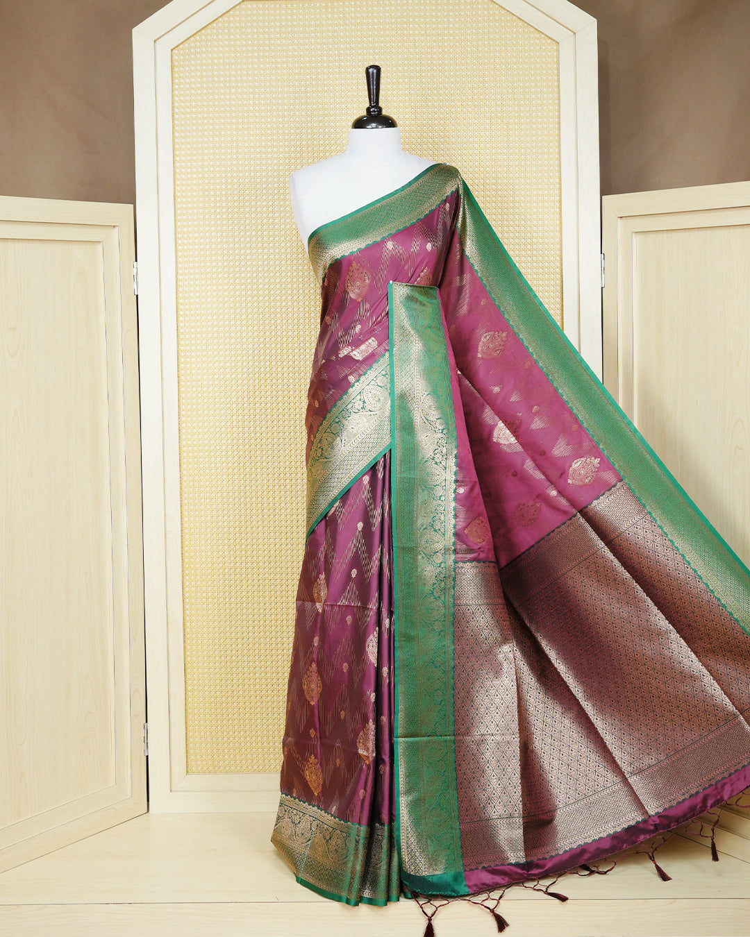 Maroon colour Mulberry silk saree featuring gold floral zari patterns on body, paired with contrast green colour with traditional border, comes with matching blouse piece.