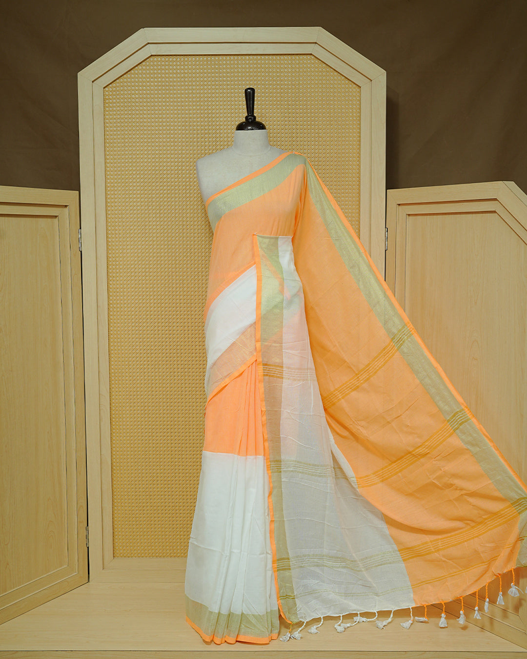 Orange & White Colour Mul Cotton Saree featuring a soft dual-tone body with a subtle golden zari border, elegant striped zari detailing on the pallu, and white tassels.