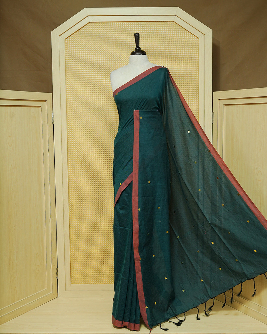 Dark Green Colour Mul Cotton Saree featuring delicate gold sequin detailing on the body, a contrasting maroon border, finished with black tassels.