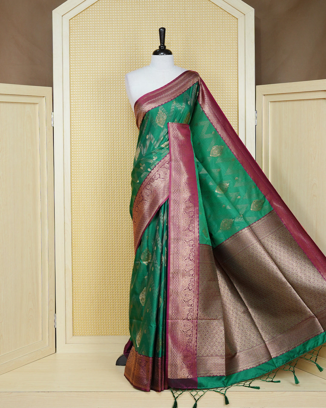 Green colour Mulberry silk saree featuring gold floral zari patterns on body, paired with contrast maroon colour with traditional border, comes with matching blouse piece.
