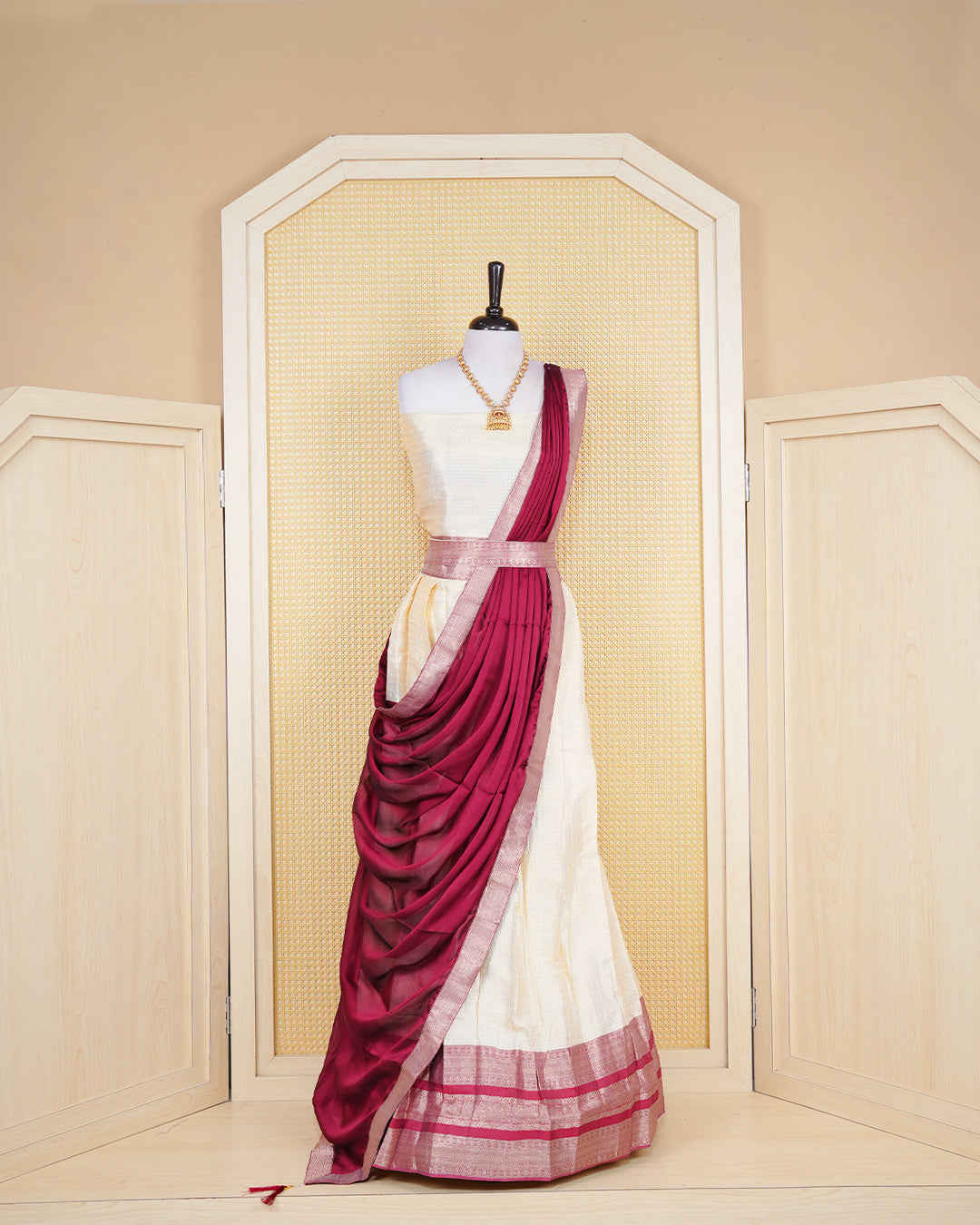 Cream colour  tissue  Semi stitched dhavani set featuring Gold zari check pattern with motifs on body ,contrast Brick Red colour with gold zari bordered skirt, paired with matching blouse piece & dupatta.