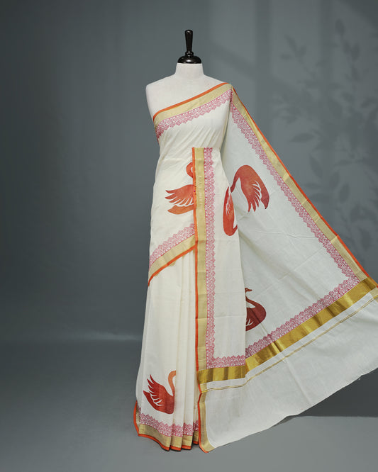 Cream colour Cotton kerala saree featuring Swan Print on the body, complemented by a gold zari with print on Border, paired with a matching blouse piece.