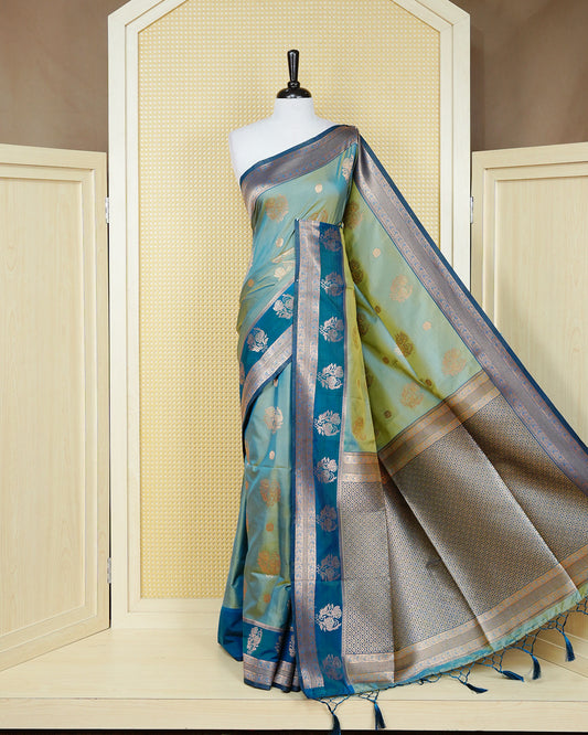 Light green & gold double shade Mulberry silk saree featuring floral gold zari patterns on body, paired with contrast teal colour with traditional border, comes with matching blouse piece.